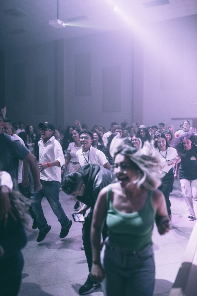 Vibrant group of people celebrating and dancing at a lively indoor party.